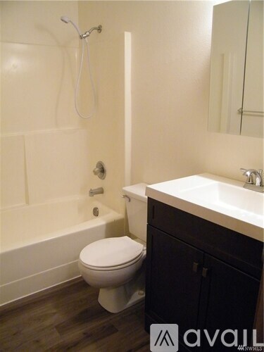 A white toilet sits in a bathroom next to a sink.