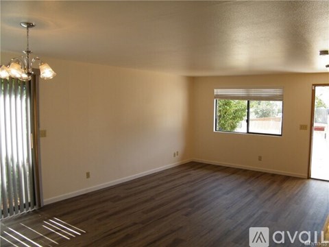 A room with wooden floors and a window with blinds.