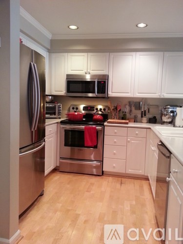 A kitchen with white cabinets and wooden floors.