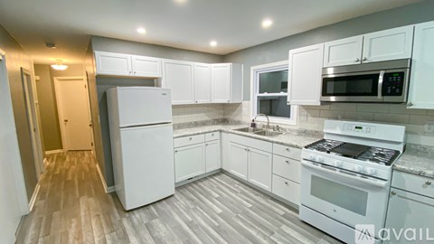 A kitchen with white appliances and cabinets.