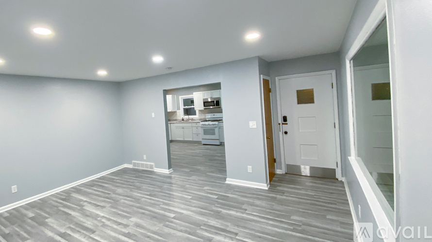 A spacious room with grey flooring and white walls.