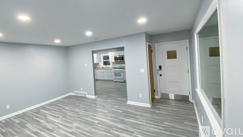 A spacious room with grey flooring and white walls.