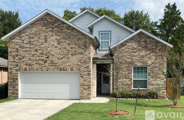A two-story house with a garage door and a driveway.