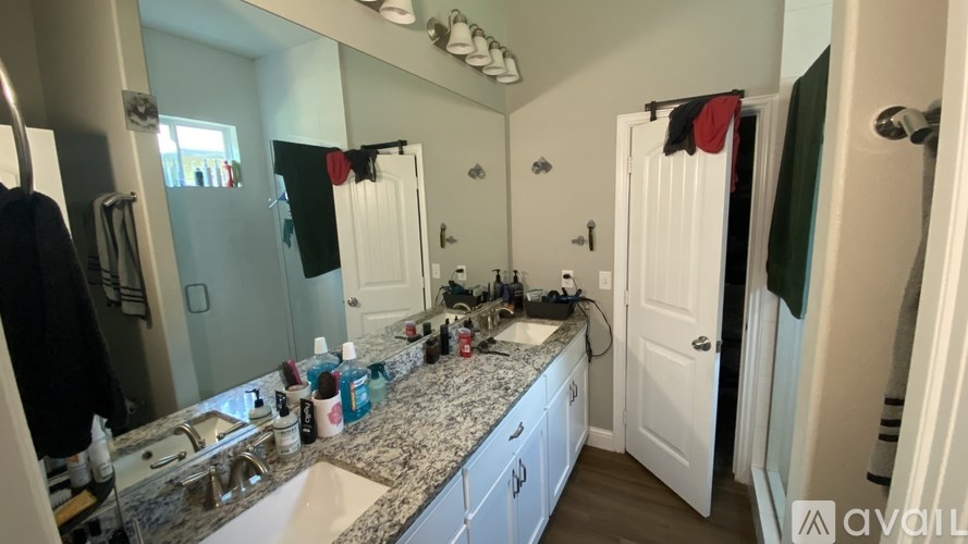 A bathroom with a granite countertop and white cabinets.