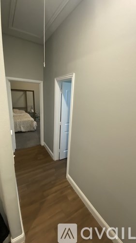 A room with a bed and a doorway leading to another room.