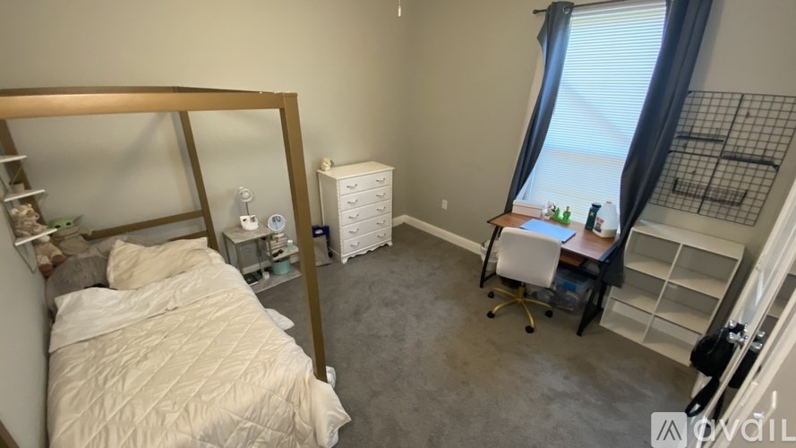 A bedroom with a bed, desk, and chair.