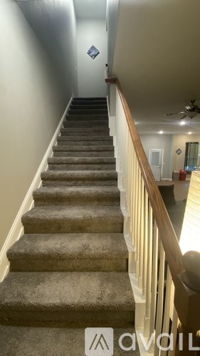A staircase with a carpeted runner and wooden balusters.