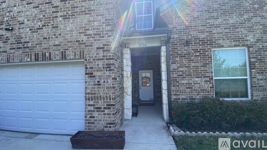 A house with a white garage door and a brick facade.
