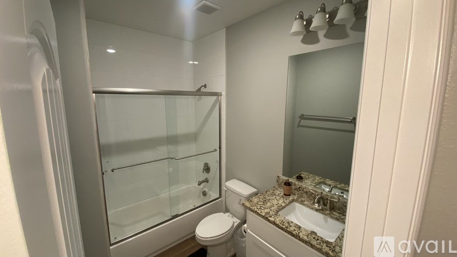 A bathroom with a toilet, sink, and shower.