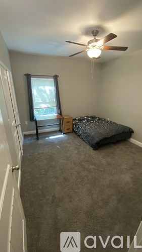 A bedroom with a bed, dresser, and window.