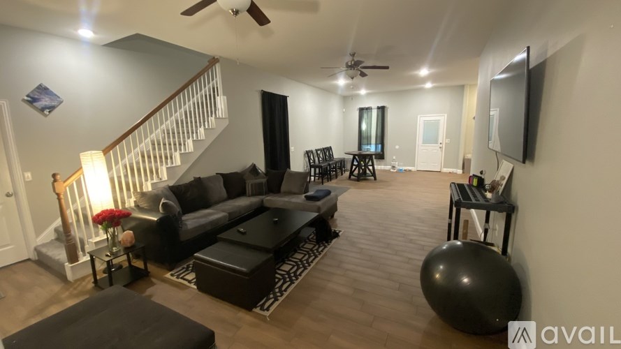 A living room with a couch, a chair, a TV, and a ball.