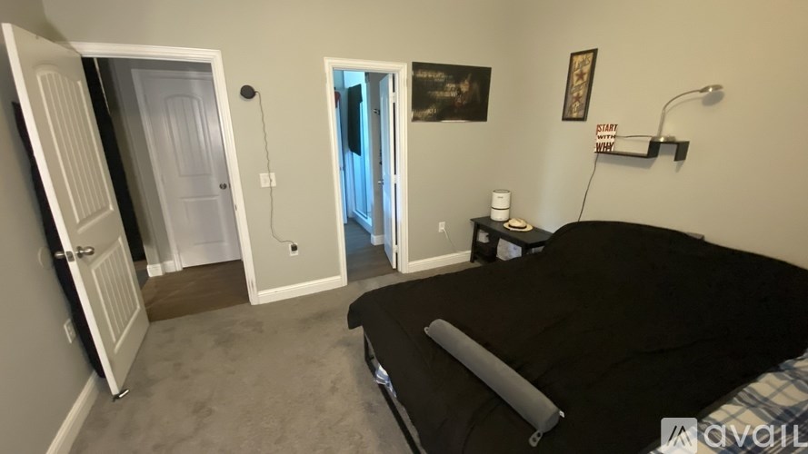 A bedroom with a bed, a lamp, and a painting on the wall.