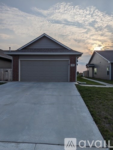 A house with a garage door in front of it.