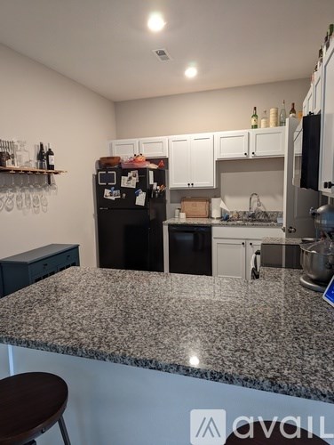 A kitchen with granite countertops and white cabinets.