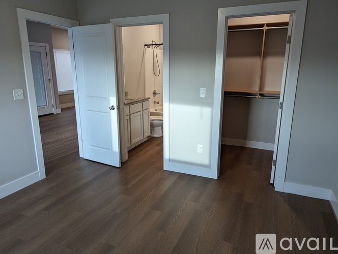 A bathroom with a shower and a toilet is open to a hallway.