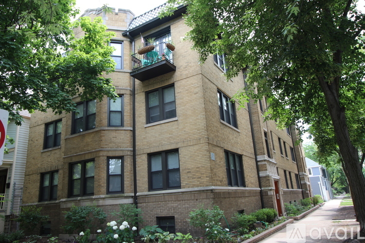 A building with a balcony and trees in front.