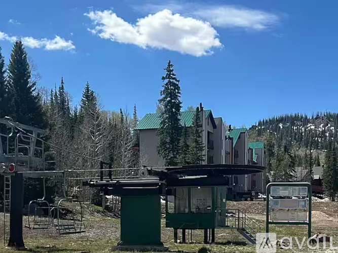 A ski resort with a mountain in the background and a sign that says "Ski in Ski Out".