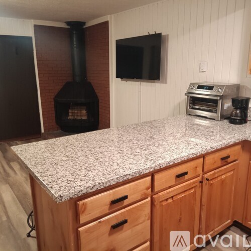 A kitchen with a granite countertop and wooden cabinets.