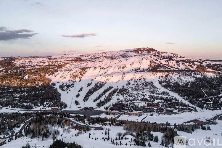 A mountainous landscape with a small town and ski slopes.