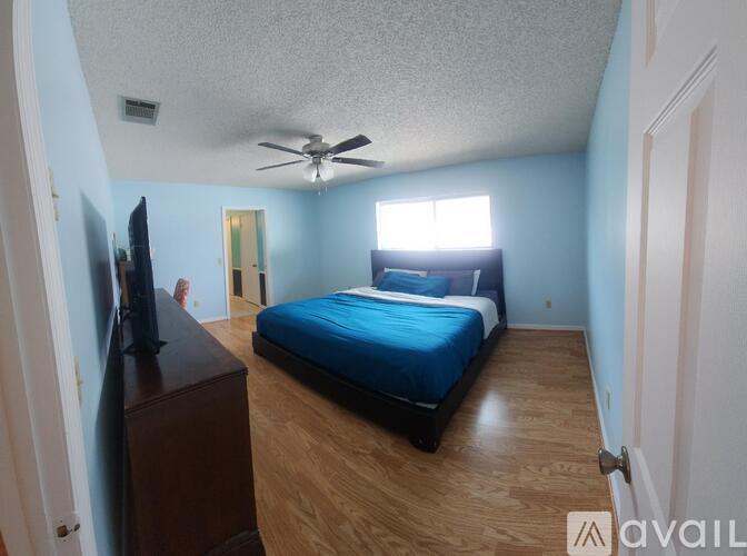 A bedroom with a bed, dresser, and television.