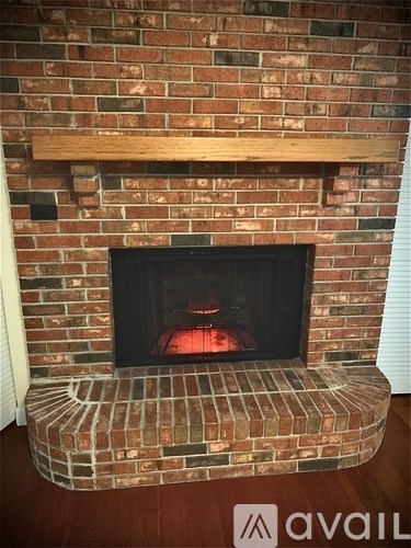 A brick fireplace with a wooden mantle and a brick hearth.