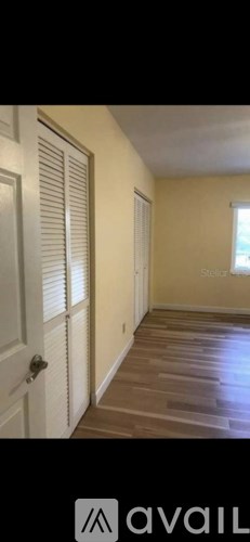 A room with wooden flooring and a white door.