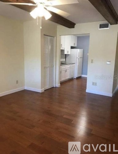 A room with wooden floors and a ceiling fan.