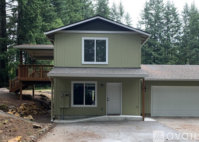 A two-story house with a garage and a deck.