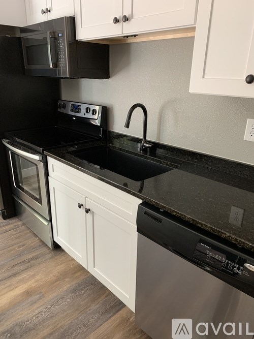 A kitchen with black countertops and white cabinets.