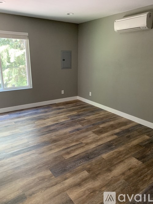 A room with wooden flooring and a window.