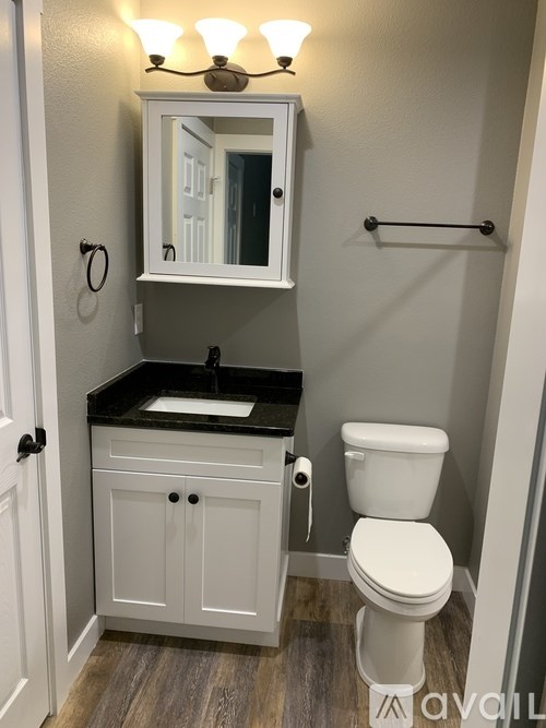 A white toilet sits under a mirror in a bathroom.
