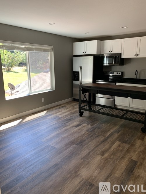 A kitchen with a refrigerator, microwave, and oven.