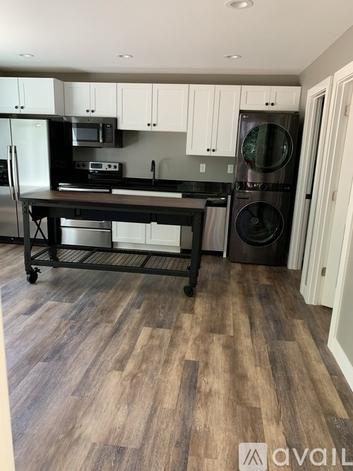 A kitchen with a black fridge, microwave, and oven.