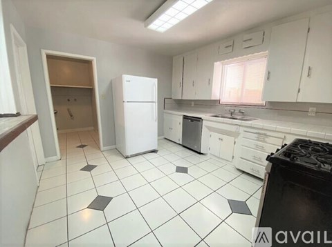 A kitchen with white cabinets and a black stove top oven.