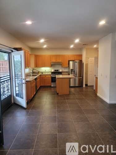 A kitchen with wooden cabinets and a tiled floor.