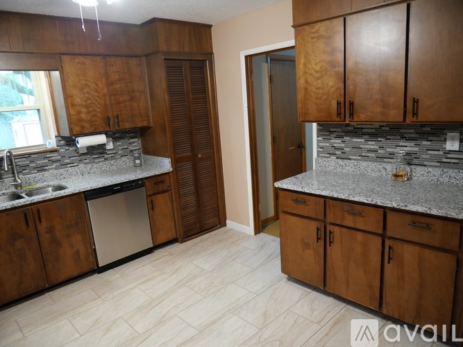 A kitchen with wooden cabinets and granite countertops.