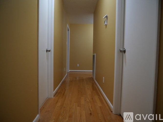 A long hallway with white doors on both sides.