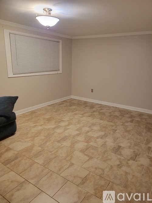 A room with a tiled floor and a window with blinds.