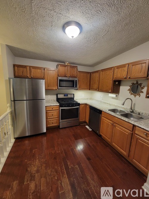 A kitchen with wooden cabinets and a refrigerator.