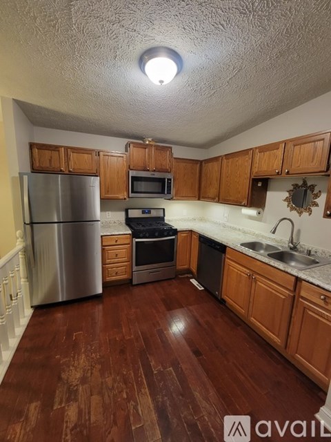 A kitchen with wooden cabinets and a refrigerator.