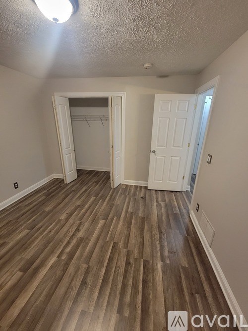 A room with wooden flooring and a white door.