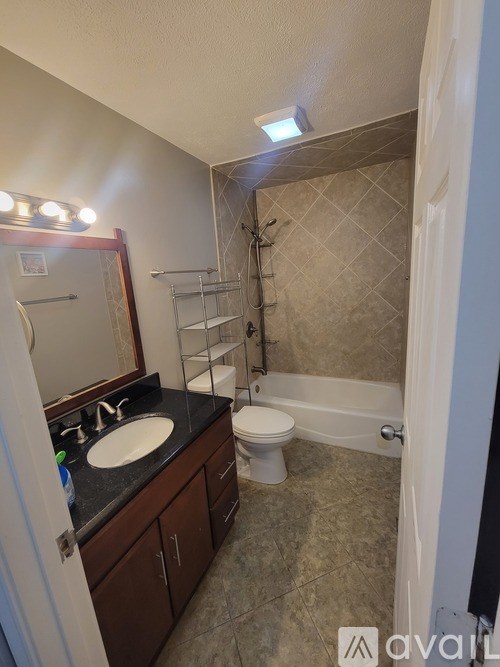 A bathroom with a sink, toilet, and bathtub.
