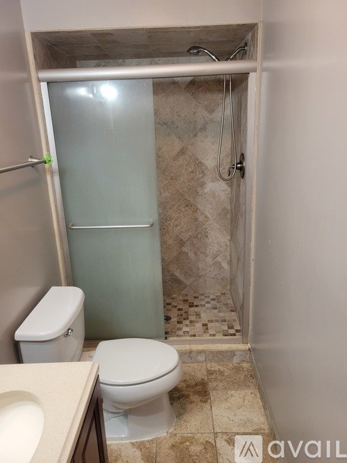A bathroom with a toilet, sink, and shower.