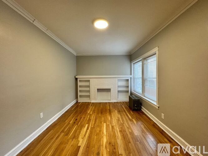 A room with wooden floors and a fireplace.