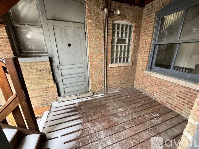 A wooden deck with a door and a window with bars.