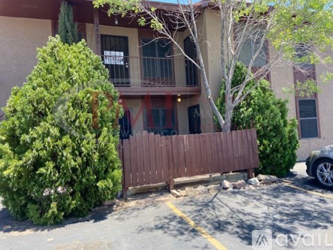 A building with a balcony and a tree in front of it.