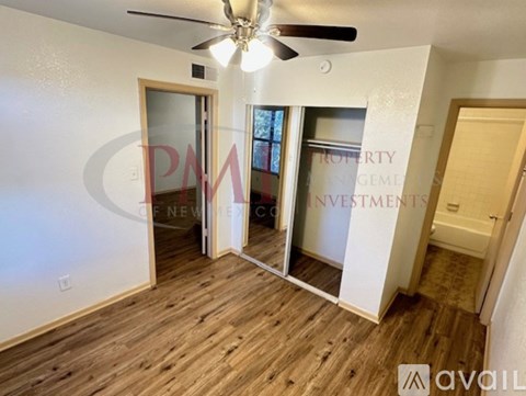 A room with wooden flooring and a ceiling fan.