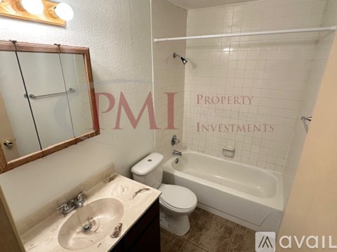 A bathroom with a tub, toilet, and sink.