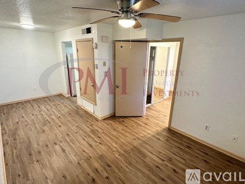 A room with wooden flooring and a ceiling fan.