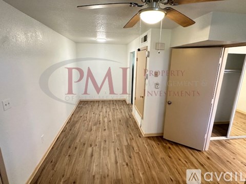 A room with wooden flooring and a ceiling fan.
